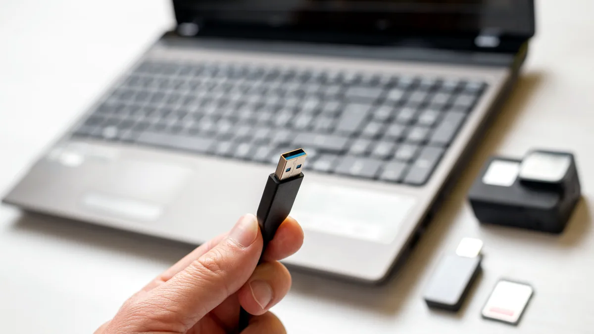 A USB flash drive inserted into a laptop USB port with a boot menu on screen.