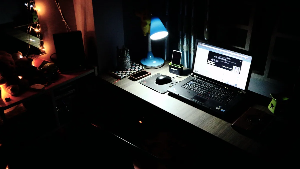 A content creator desk with a Linux laptop, microphone, and a second monitor.