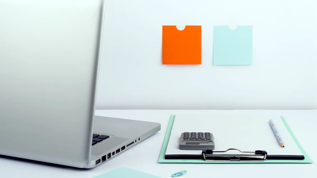 A tiny single file sitting on a desk next to an open laptop with a terminal.